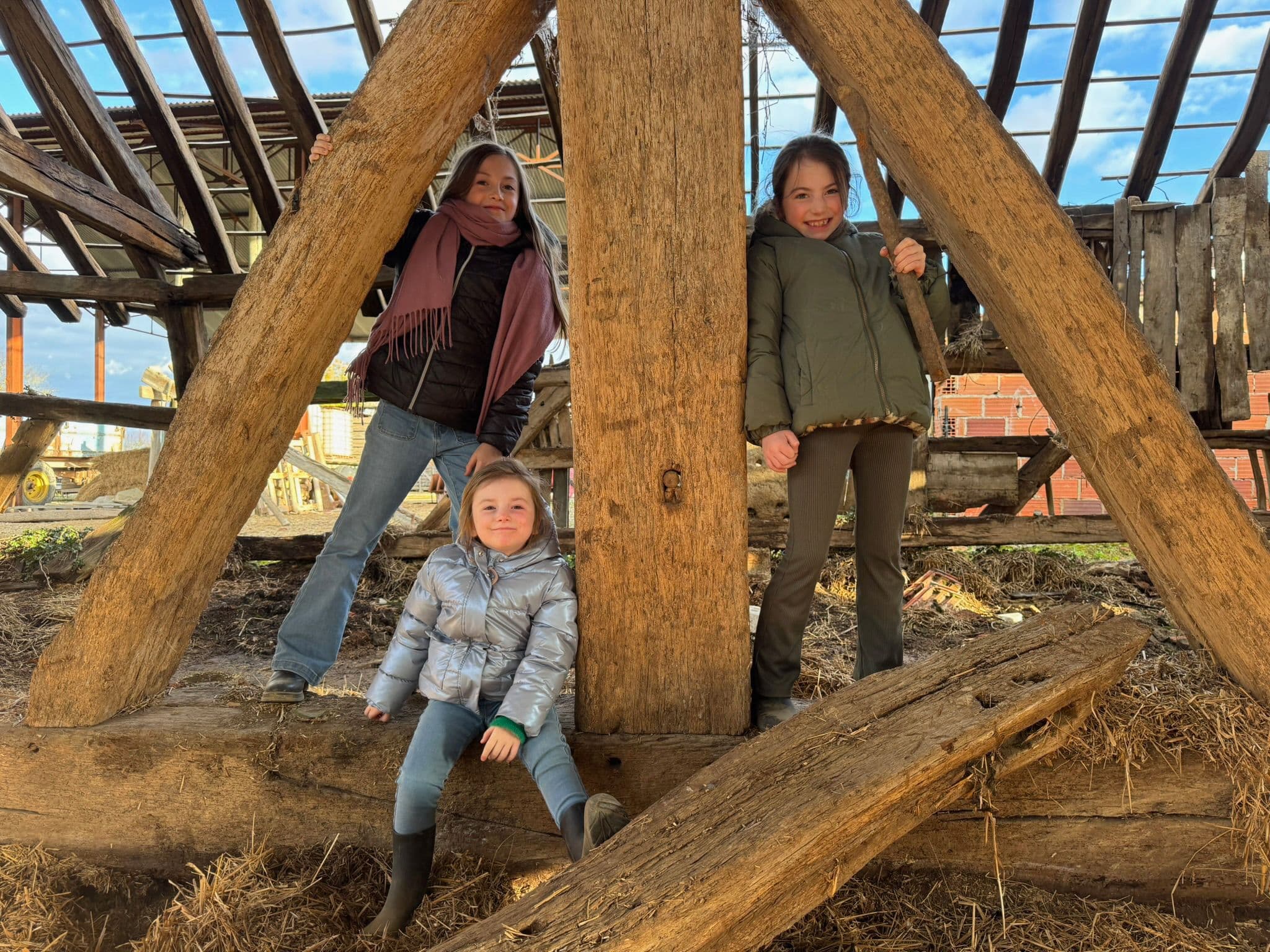 The LeSeurre daughters in front of the rising 1487 barn — the next generation.